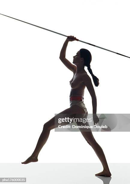 half-nude woman preparing to throw javelin, side view - womens field event fotografías e imágenes de stock