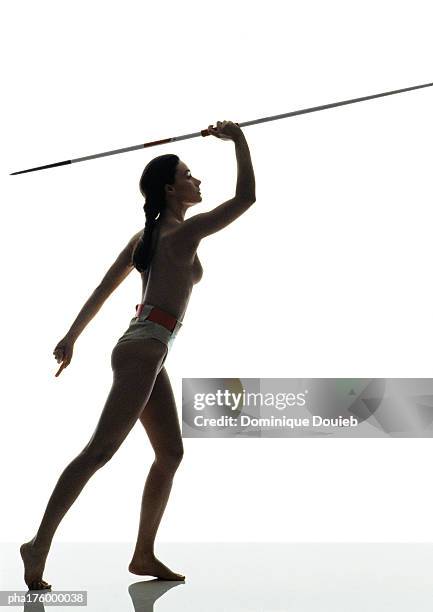 half-nude woman preparing to throw javelin, side view - women's field event 個照片及圖片檔