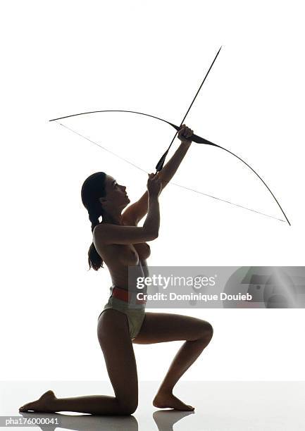 half-nude woman kneeling, bending bow, side view - president trump hosts public safety medal of valor awards at white house stockfoto's en -beelden