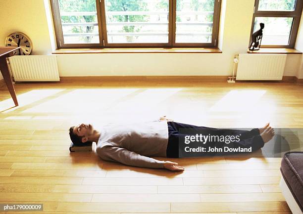 man lying on floor - savasana stock pictures, royalty-free photos & images