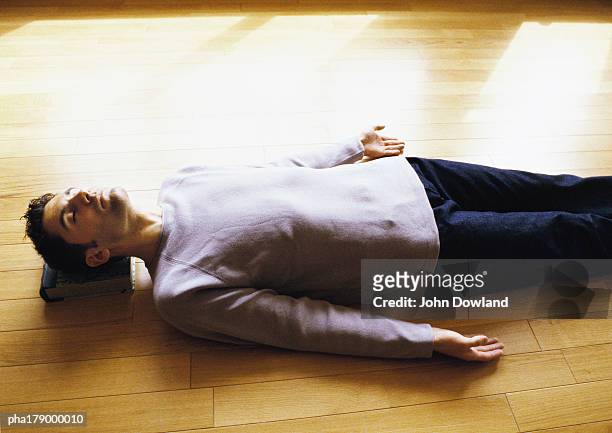 man lying on floor - savasana stock pictures, royalty-free photos & images