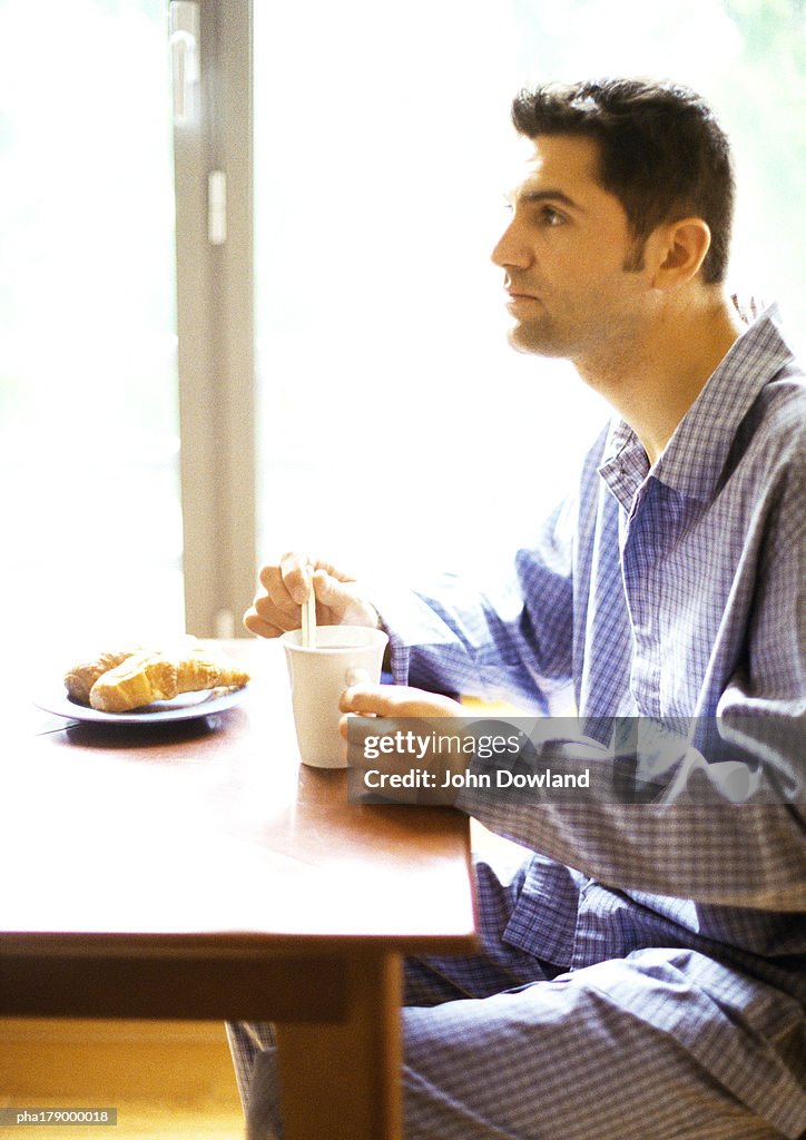 Man in nightshirt having breakfast