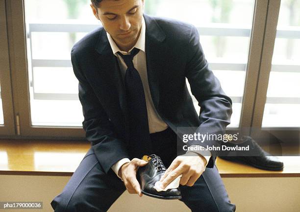 man in suit polishing shoe, close-up - polishing shoes foto e immagini stock