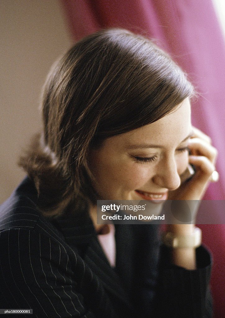 Woman with cell phone, smiling, close-up