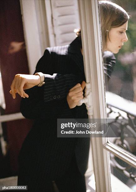 woman looking out of window - being watched stockfoto's en -beelden