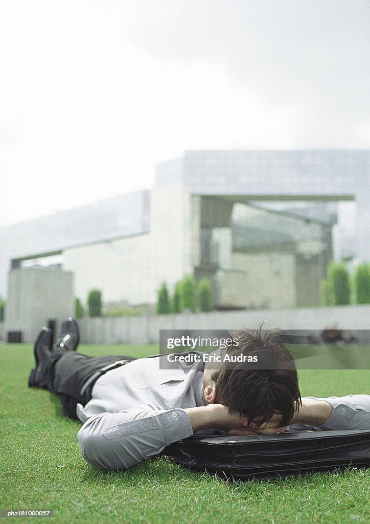 Businessman lying on grass