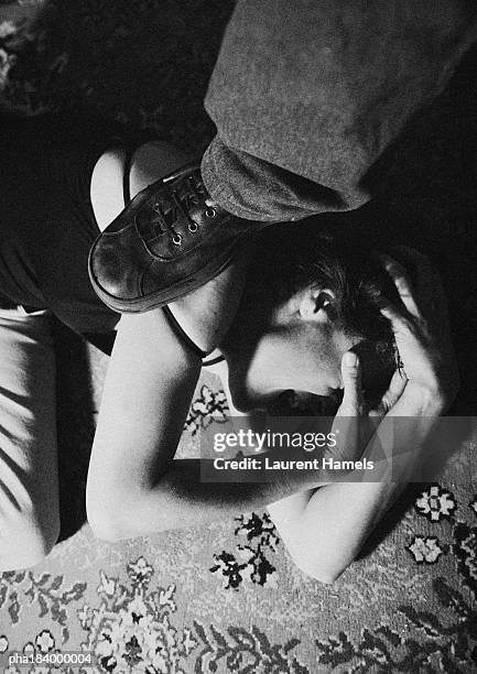 foot standing on woman curled up on ground, close-up, b&w - maquereau photos et images de collection