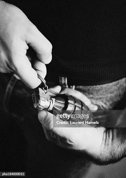 man taking the pin out of grenade, close-up, b&w - hand grenade stock pictures, royalty-free photos & images