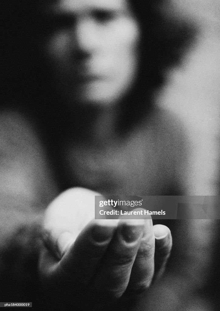 Woman holding hand out, blurred, b&w