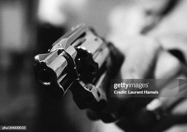 hand holding gun, close-up, b&w - gun foto e immagini stock