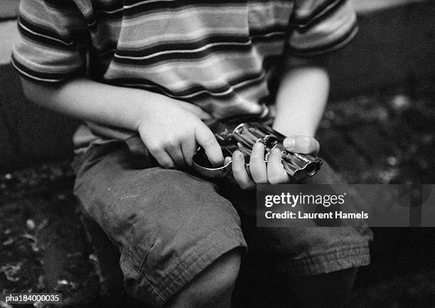 child holding gun, mid-section, b&w - arme à feu photos et images de collection