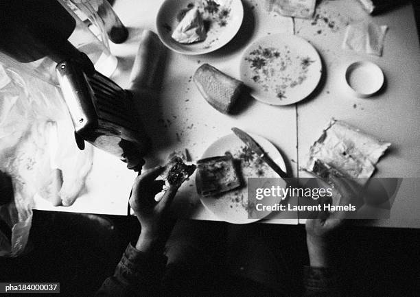 hands holding food on dirty table, b&w - suprasensorial - fotografias e filmes do acervo