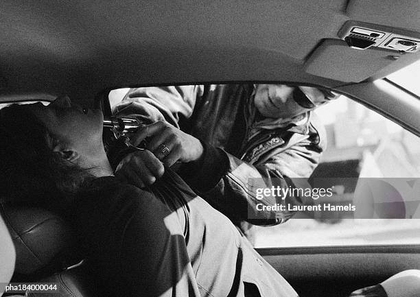 man threatening woman in car with gun, b&w - criminal offense stock pictures, royalty-free photos & images