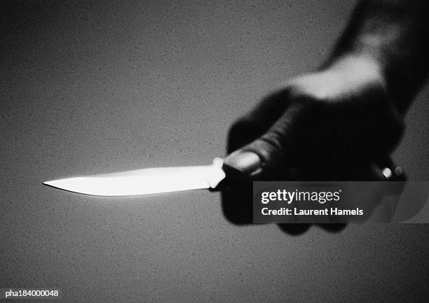 hand holding knife, close-up, b&w - killer stockfoto's en -beelden