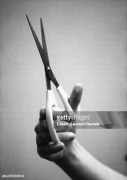 hand holding scissors, close-up, b&w - intersected stock pictures, royalty-free photos & images