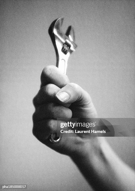 hand holding crescent wrench, close-up, b&w - struik stock pictures, royalty-free photos & images