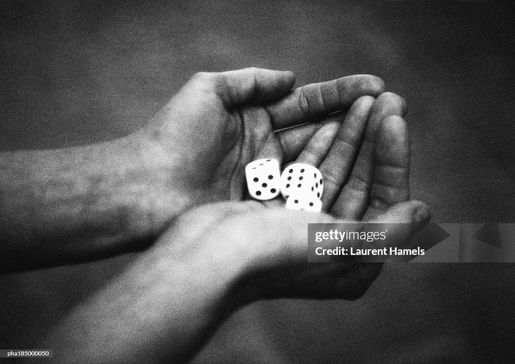 Hands holding dice, close-up, b&w