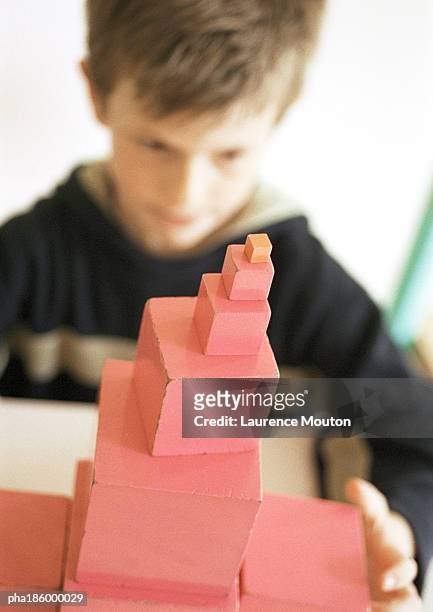child in background, blurred, stacked blocks in foreground, in focus, close-up - being watched stockfoto's en -beelden