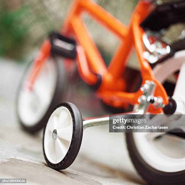 child's bike with training wheels, close up. - stützrad stock-fotos und bilder