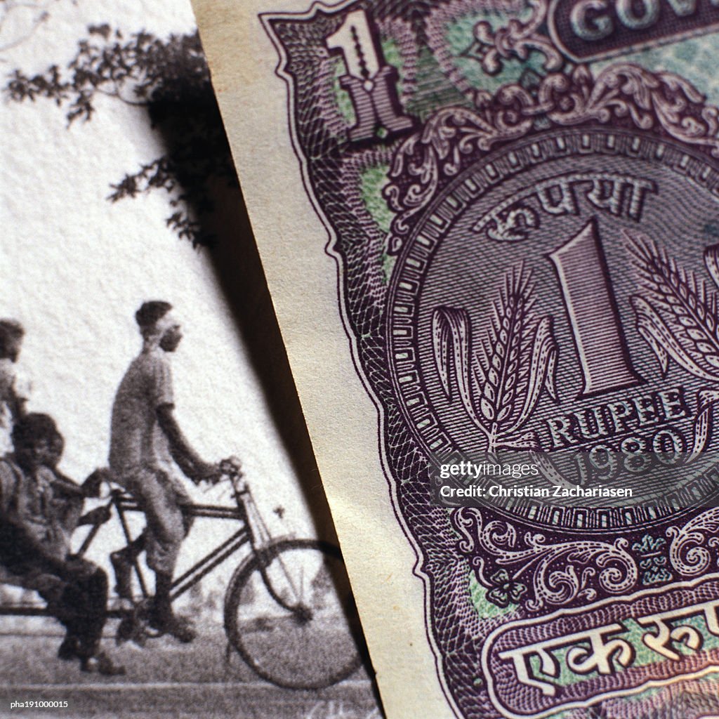 Paper bill next to old photograph.