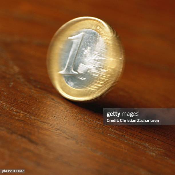 euro coin spinning on table. - rollup photos et images de collection