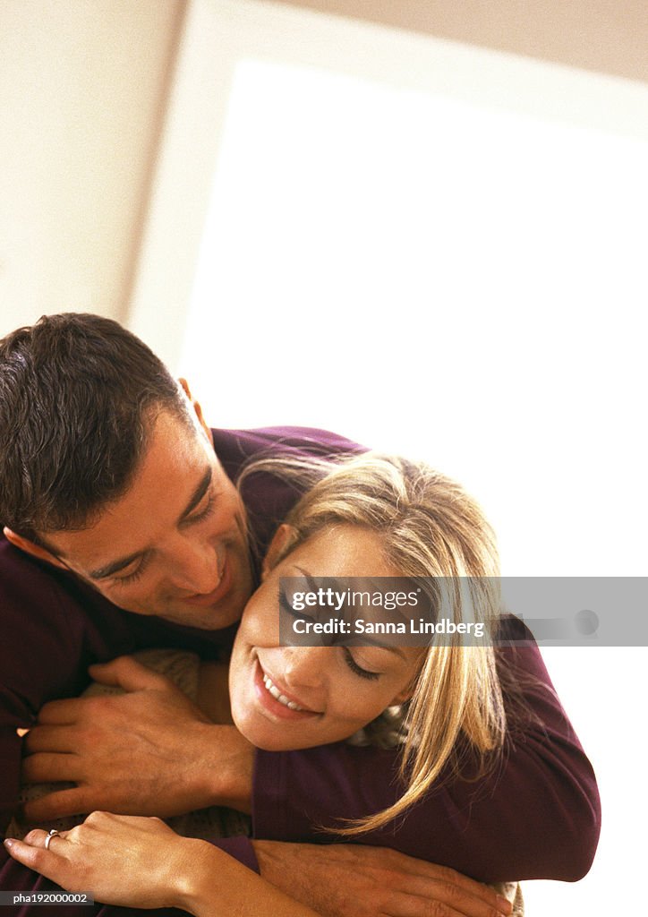 Man hugging woman, head and shoulders, off centered, tilt