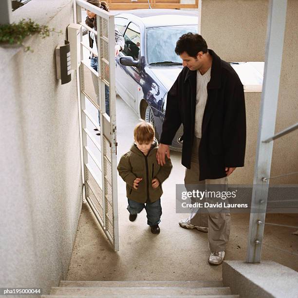 father coming in door with with son, full length, high angle view - laurens foto e immagini stock