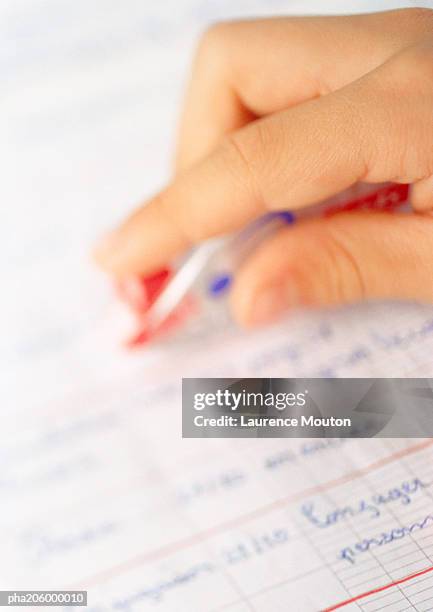 hand holding pen over school book. - intersected stock pictures, royalty-free photos & images