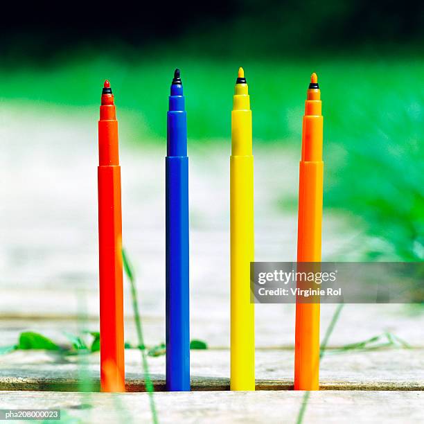 colored felt-tip pens sticking out the ground. - colouring stockfoto's en -beelden