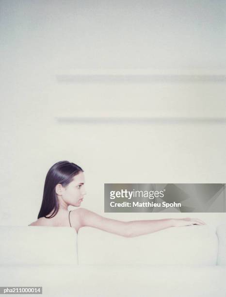 woman sitting on a chair, rear view. - being watched stockfoto's en -beelden
