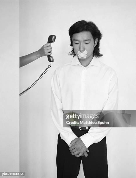 man with mouth taped, being handed a telephone, b&w. - gagged stock pictures, royalty-free photos & images