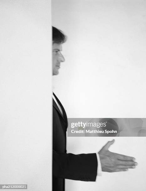 man standing behind a wall, holding hand out, blurred, b&w. - b 47 - fotografias e filmes do acervo