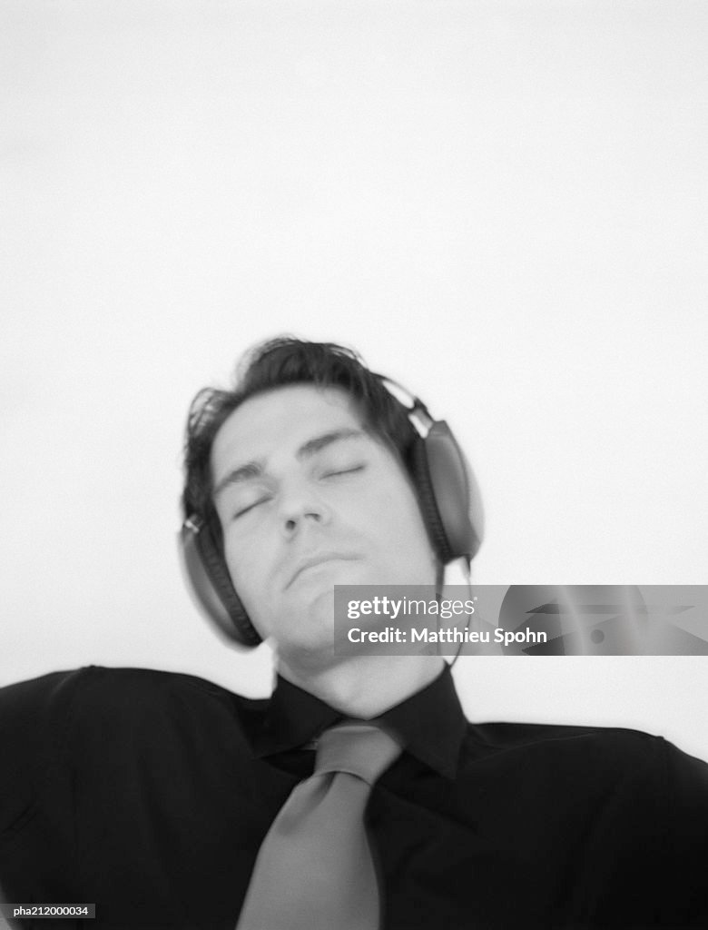 Man listening to headphones, slightly blurred, b&w.