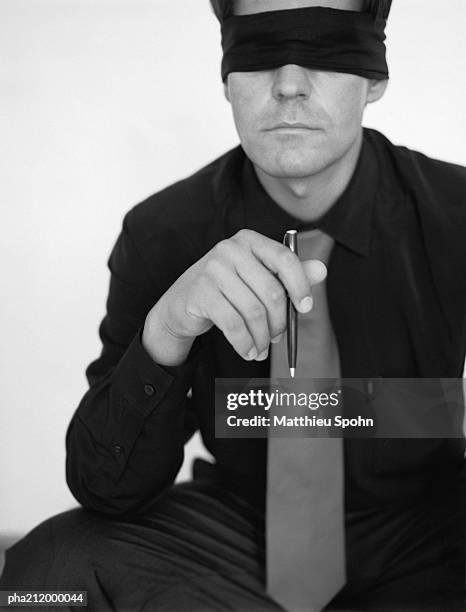 man wearing blindfold, holding a pen, b&w. - the weinstein company with the cinema society forevermark host the premiere of w e stockfoto's en -beelden