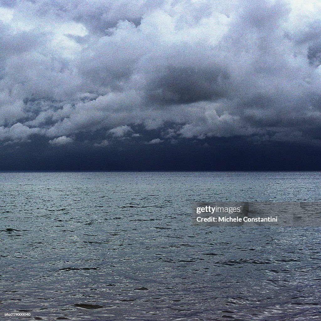 Sea, under grey clouding sky.