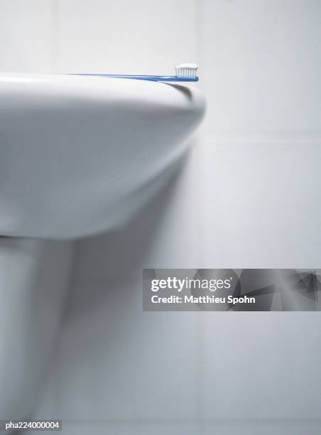 toothbrush laying on sink, partial view. - lavabo photos et images de collection