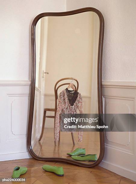 mirror reflecting chair with blouse hanging from it. - bedroom mirror stock-fotos und bilder