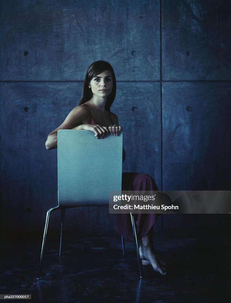 Woman sitting side saddle, looking into camera.