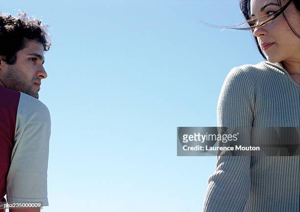 man and woman looking at each other with sky in background. - relationship difficulties stock-fotos und bilder