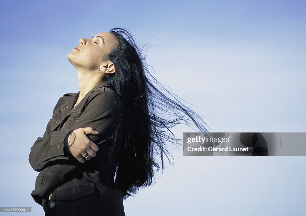 Young woman, head back, eyes close, side view.