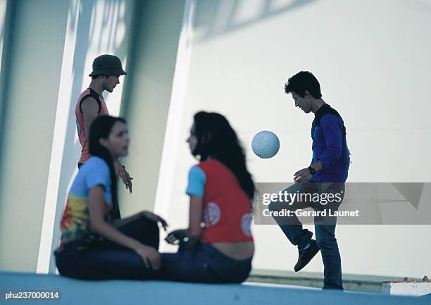 two women talking in foreground, blurred, two men playing soccer. - women talking stock pictures, royalty-free photos & images