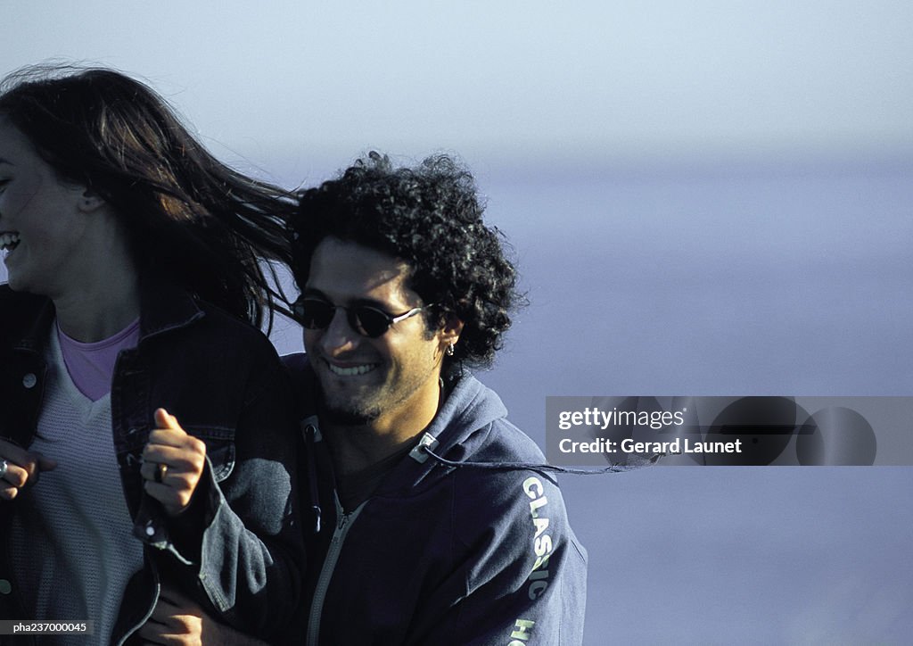 Man smiling pushing woman.