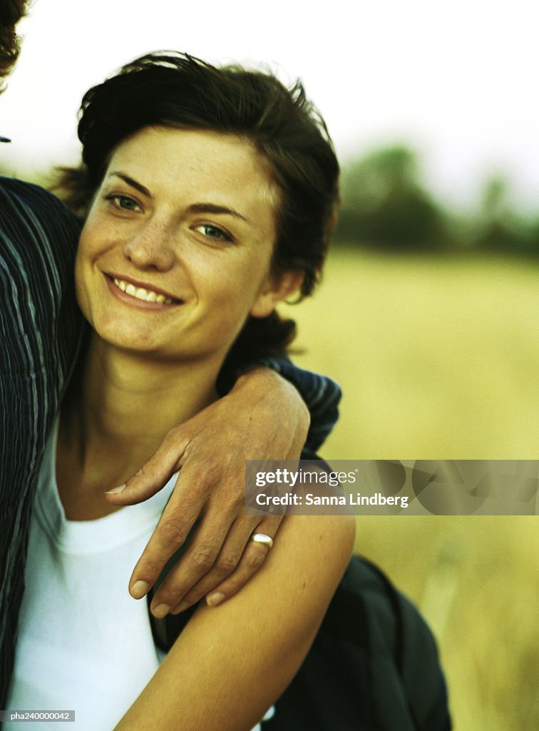 Couple arm in arm, focused on woman, portrait