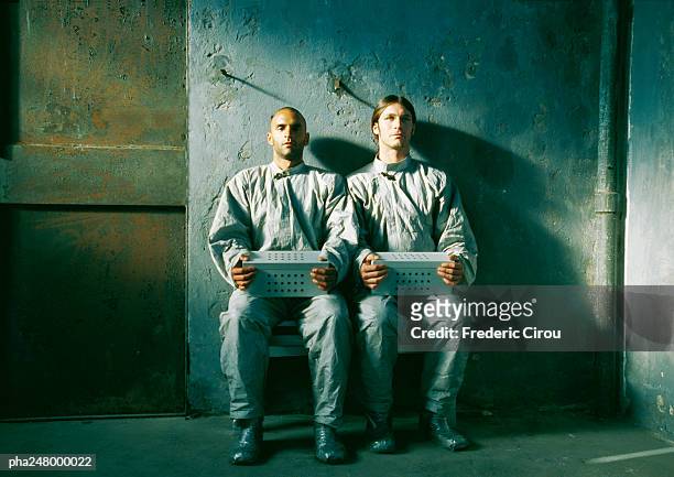 two men sitting, holding boxes - industrial doors stock pictures, royalty-free photos & images