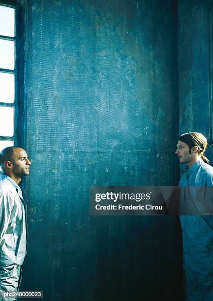 two men standing face to face, side view - industrial doors stock pictures, royalty-free photos & images