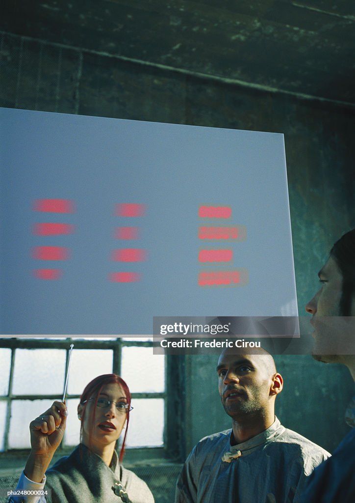 Two men and a woman looking at screen