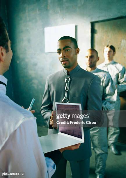 man holding laptop, three men in line - intersected stock pictures, royalty-free photos & images