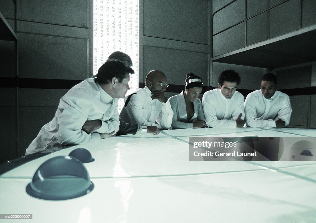 People standing around table