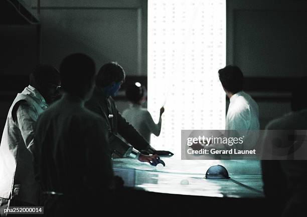 silhouettes of people in a room - being watched stockfoto's en -beelden