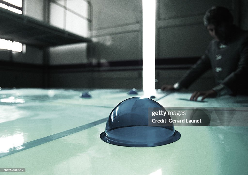 Hemispherical object on table, man in background